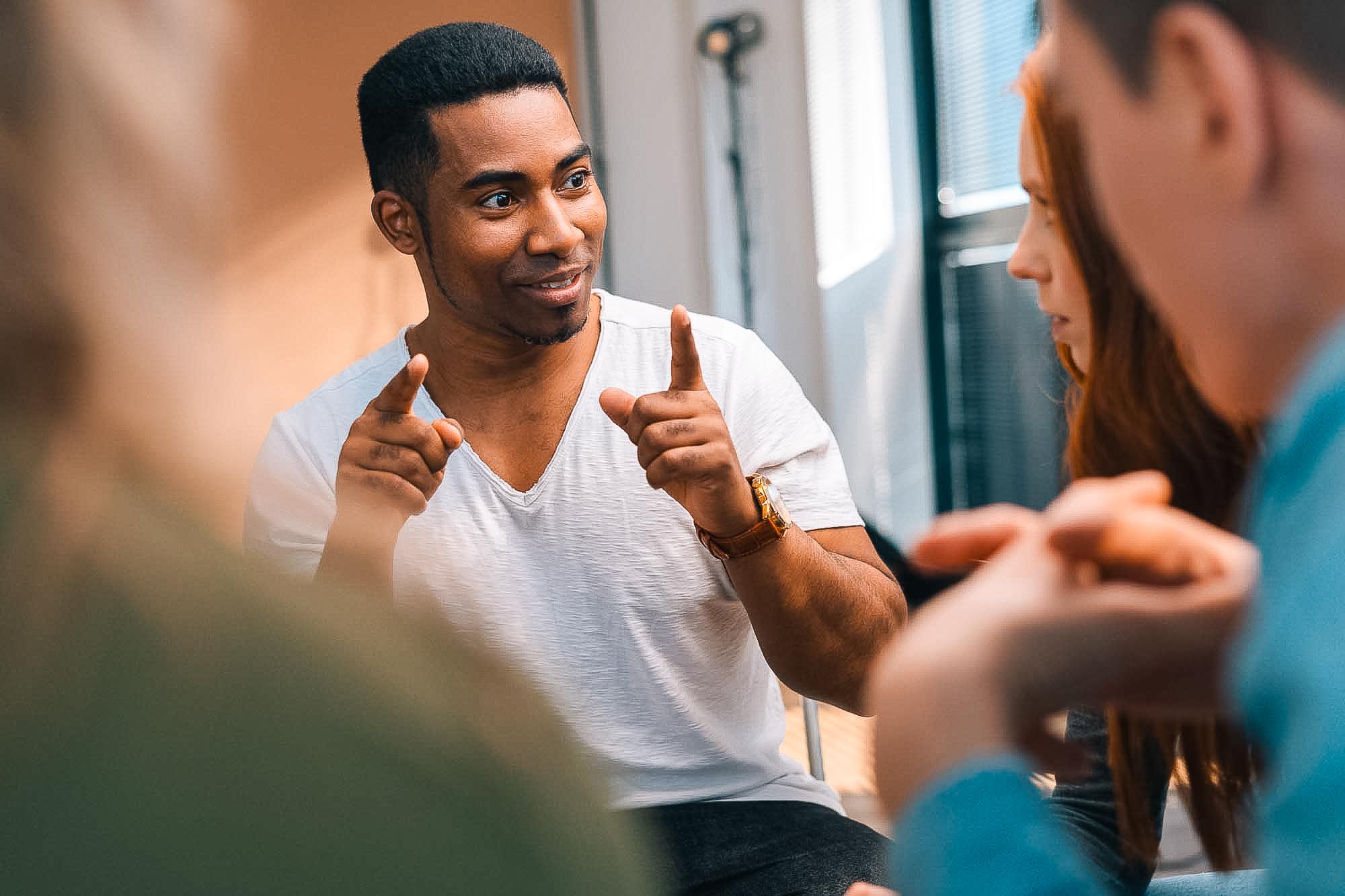 African American male leader explaining new strategies to young creative business team, during brainstorming.